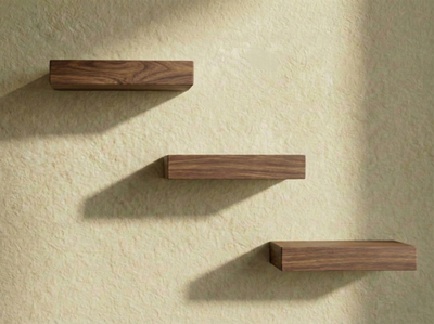 Solid walnut floating shelf set from The Mortise & The Hare, showcasing three minimalist, wall-mounted shelves on a neutral background.