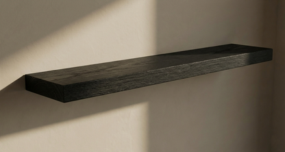 Solid black oak floating shelf from Shelving, showcasing a sleek, modern design against a white wall.