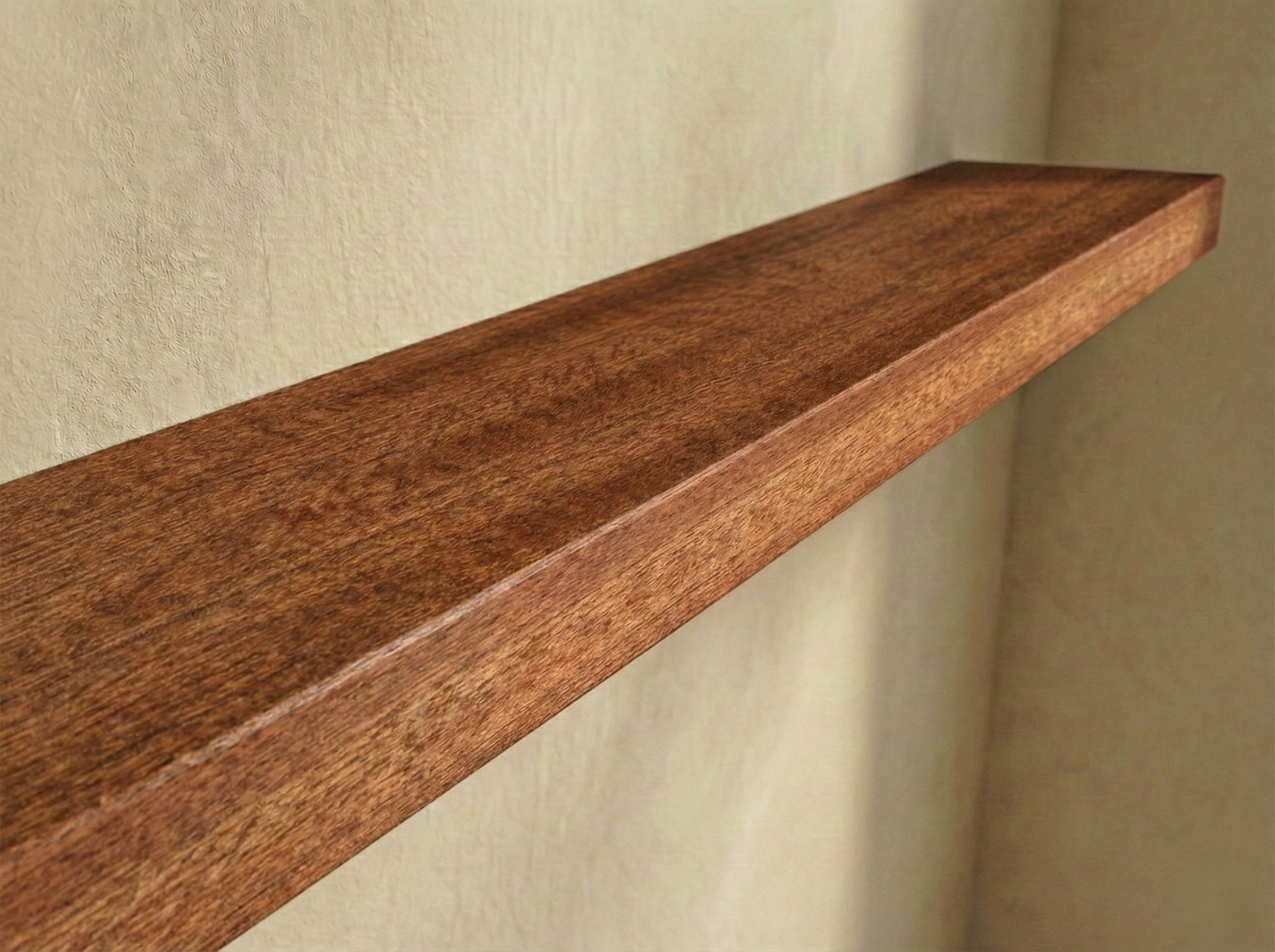 Solid mahogany floating shelf with rich grain detail, showcasing its elegant design and sturdy construction for wall display.