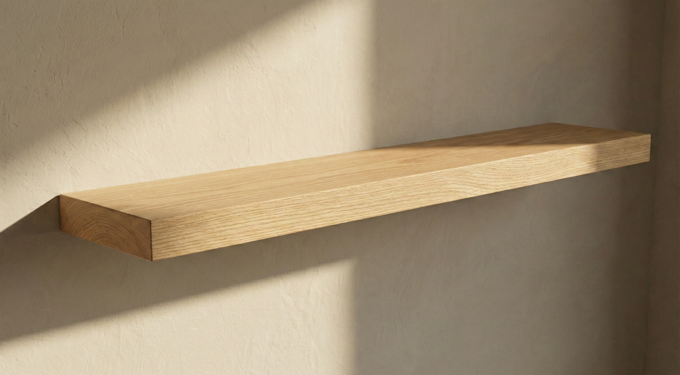 Solid white oak floating shelf by The Mortise & The Hare mounted on a wall with a minimalist design.